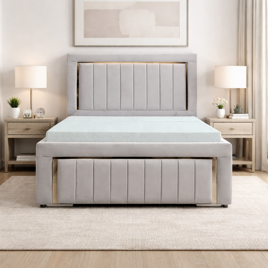 The Carter Luxury Panel Bed in soft grey upholstery with vertical panels, matching footboard and modern bedside tables in bedroom setting.