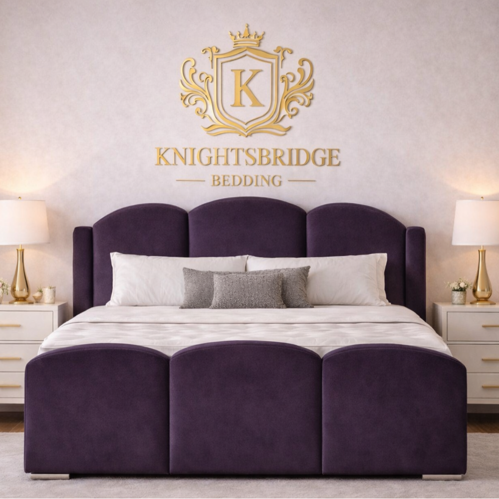 The Mayfair Wingback Luxury Bed in rich purple velvet with scalloped headboard and matching base in elegant bedroom setting.