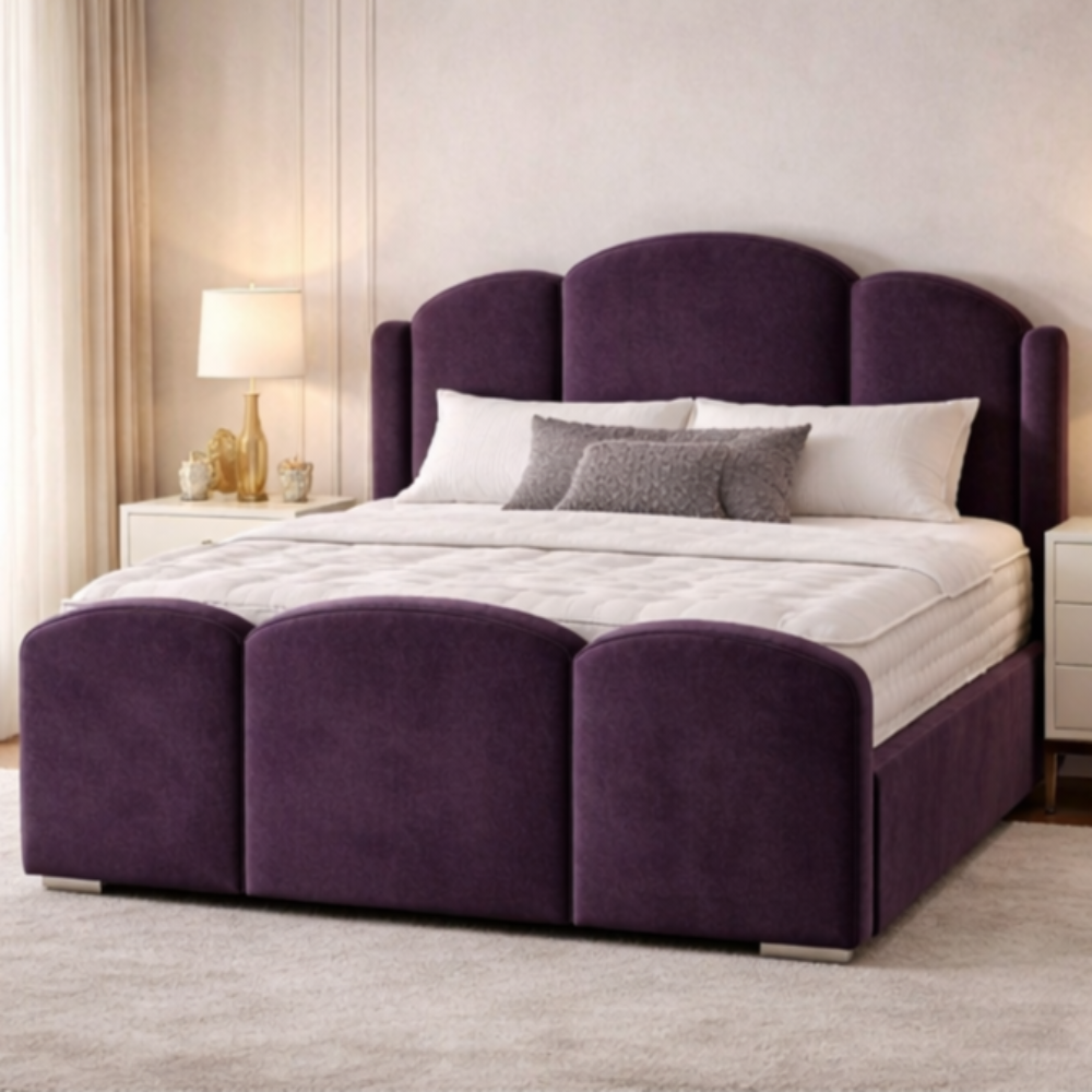 The Mayfair Wingback Luxury Bed in deep purple velvet with scalloped headboard and matching footboard in elegant UK bedroom setting.