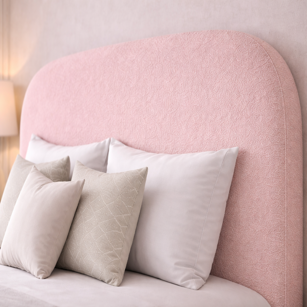 The Tate Bed Frame close up of blush pink boucle curved headboard with soft neutral cushions in a modern kids bedroom setting.
