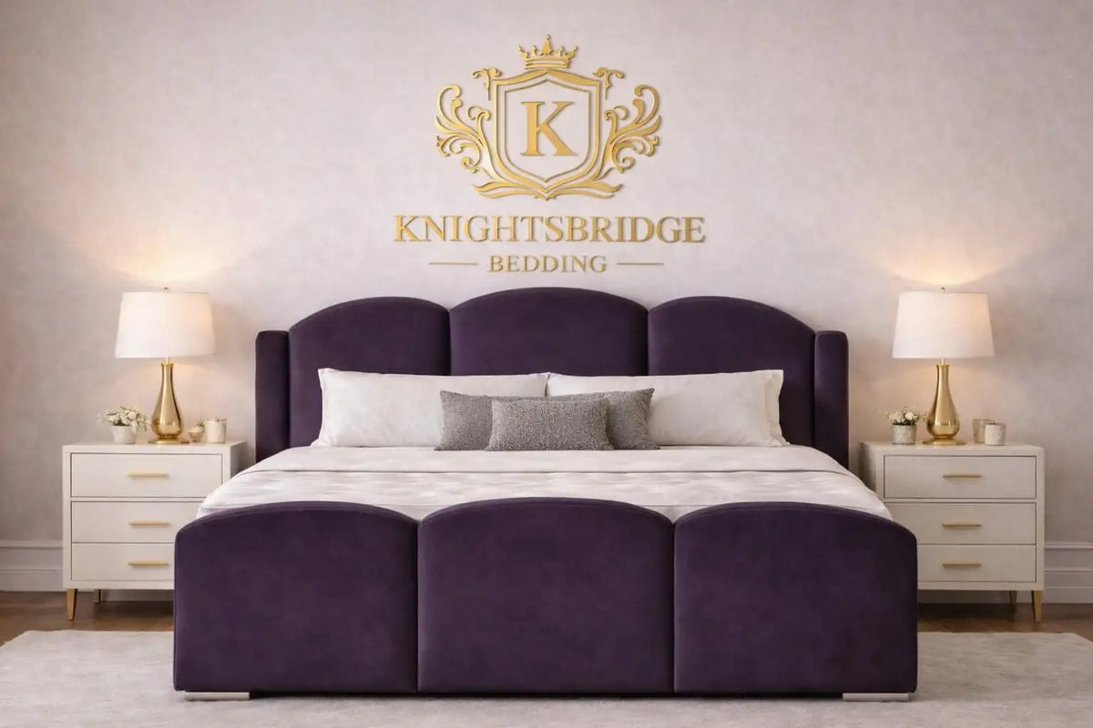 Purple bed with Knightsbridge Bedding logo on a neutral wall